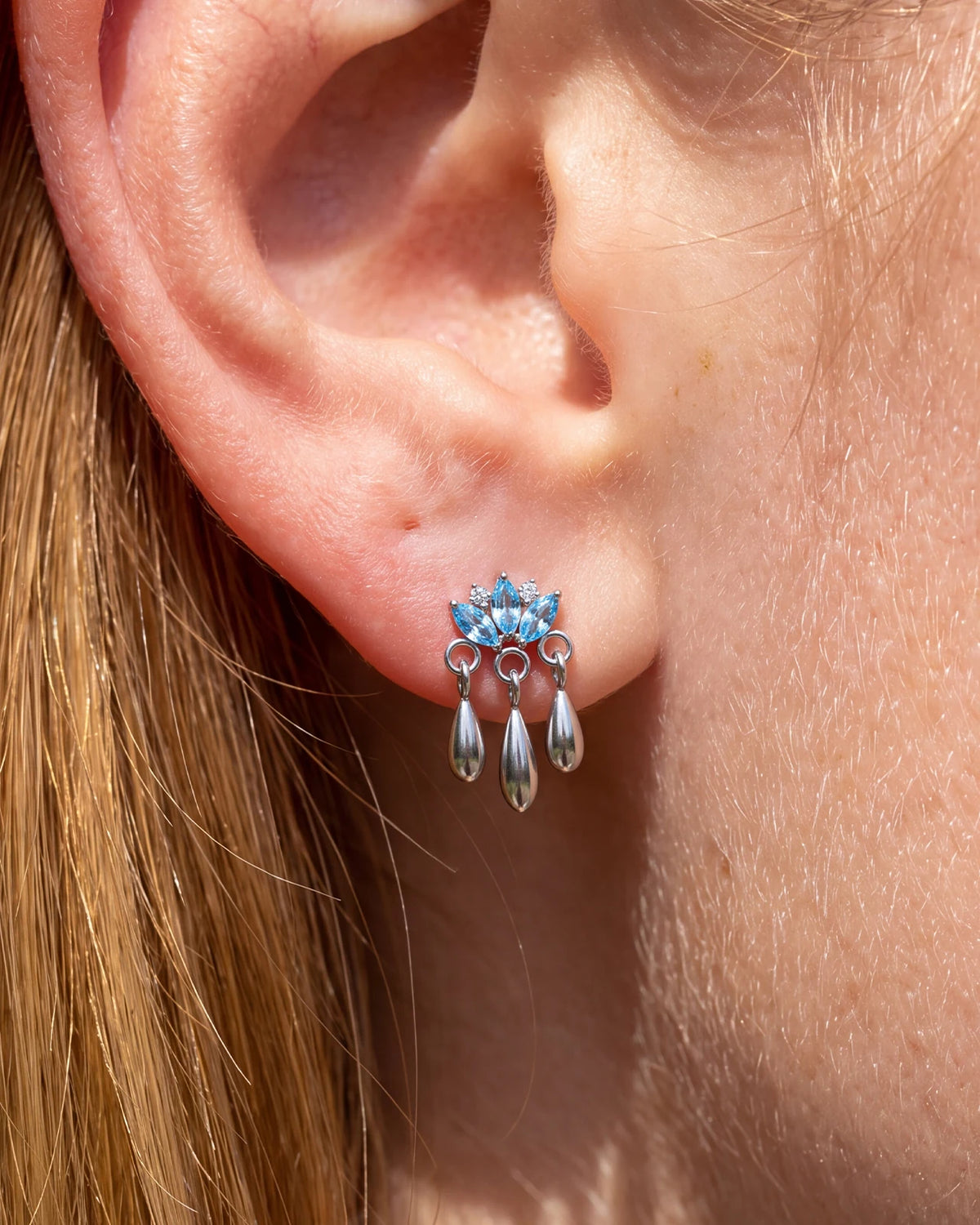 Petal Rain silver ocean blue flatback stud styled on the earlobe