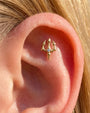 Gold Abyssal Trident flatback stud worn in an ear piercing