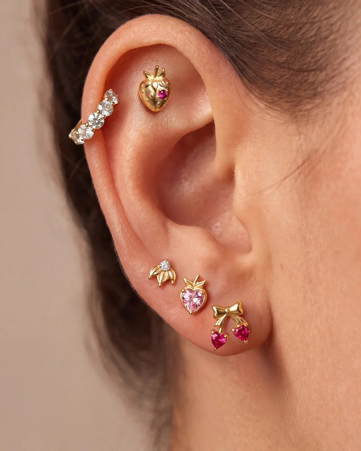 Ethereal Tide Huggie Clicker in a gold fruit ear stack with strawberry, peach, cherry and floral studs
