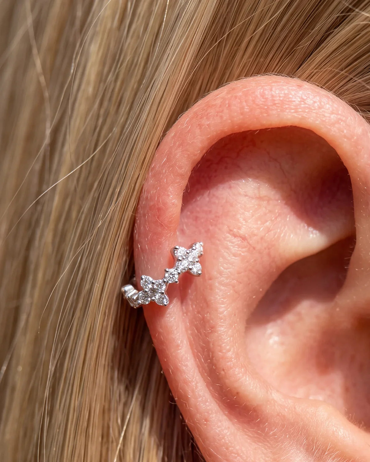 Silver Lucky Bloom Huggie Clicker worn on lobe