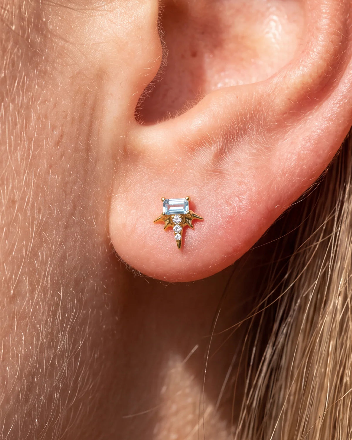 Radiant Wingcrest Flatback Stud, gold tone with light blue center stone, ear styling detail