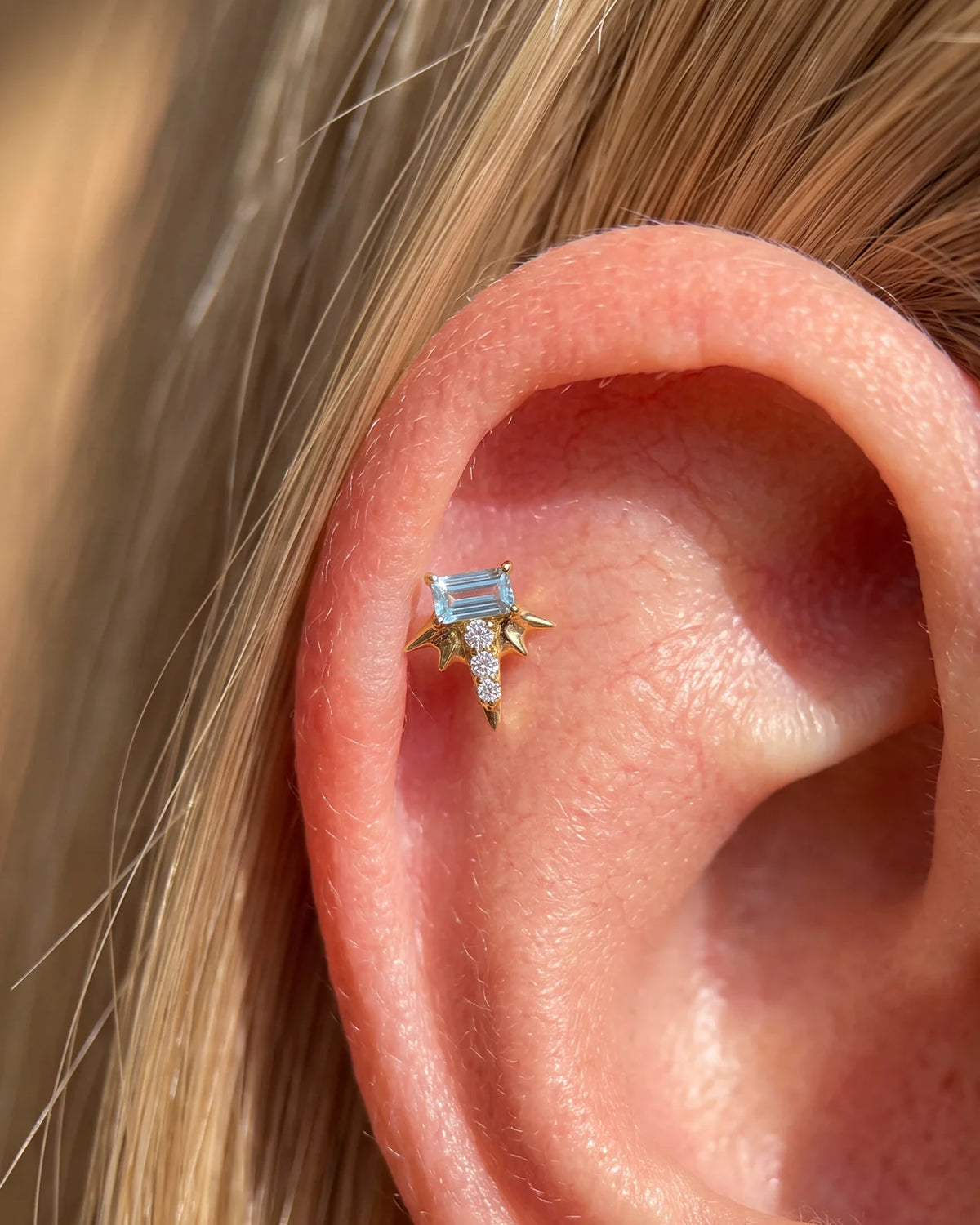 Radiant Wingcrest Flatback Stud, gold tone with light blue center stone, ear styling detail