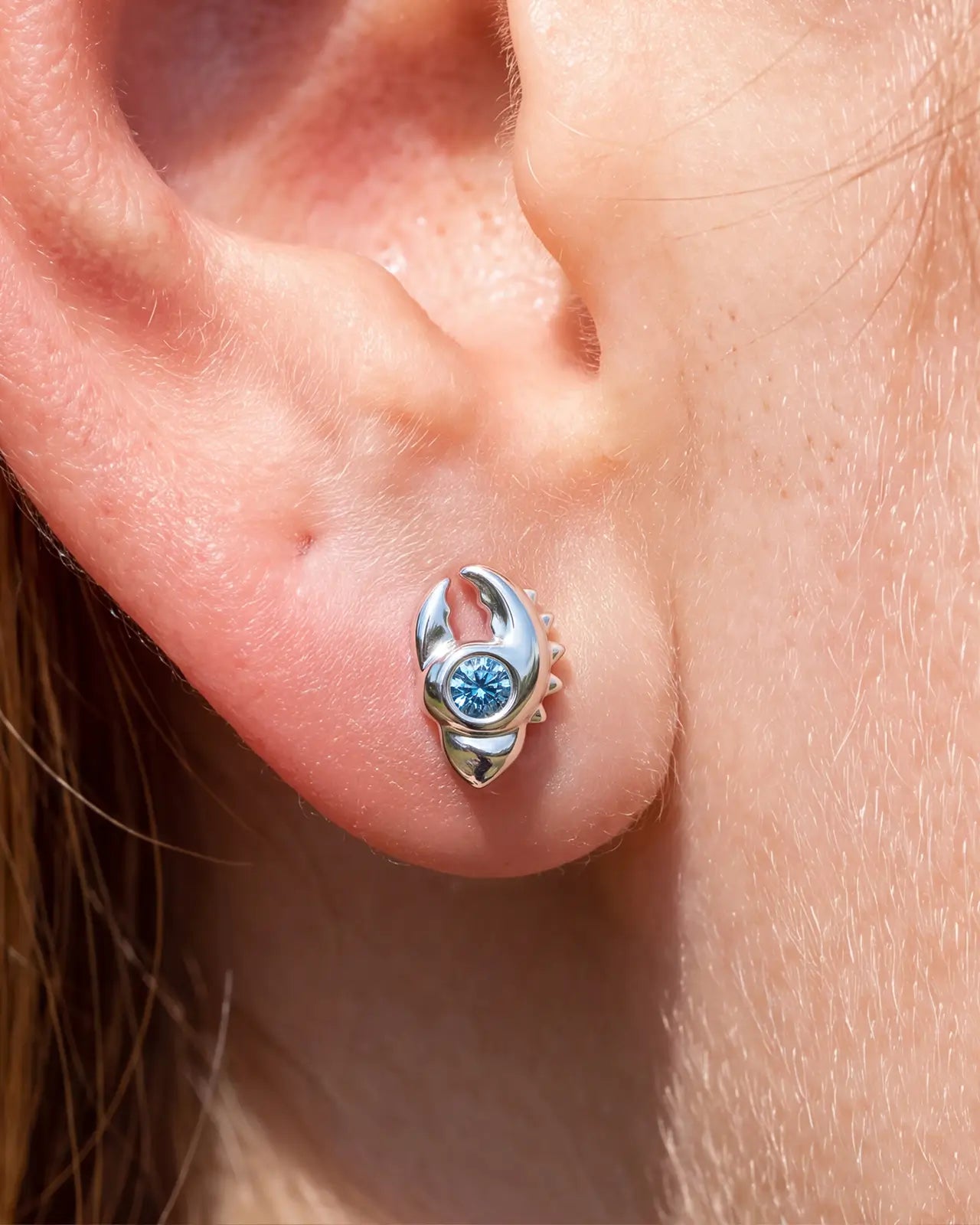Tidal Claw silver ocean mist flatback stud worn in lobe piercing